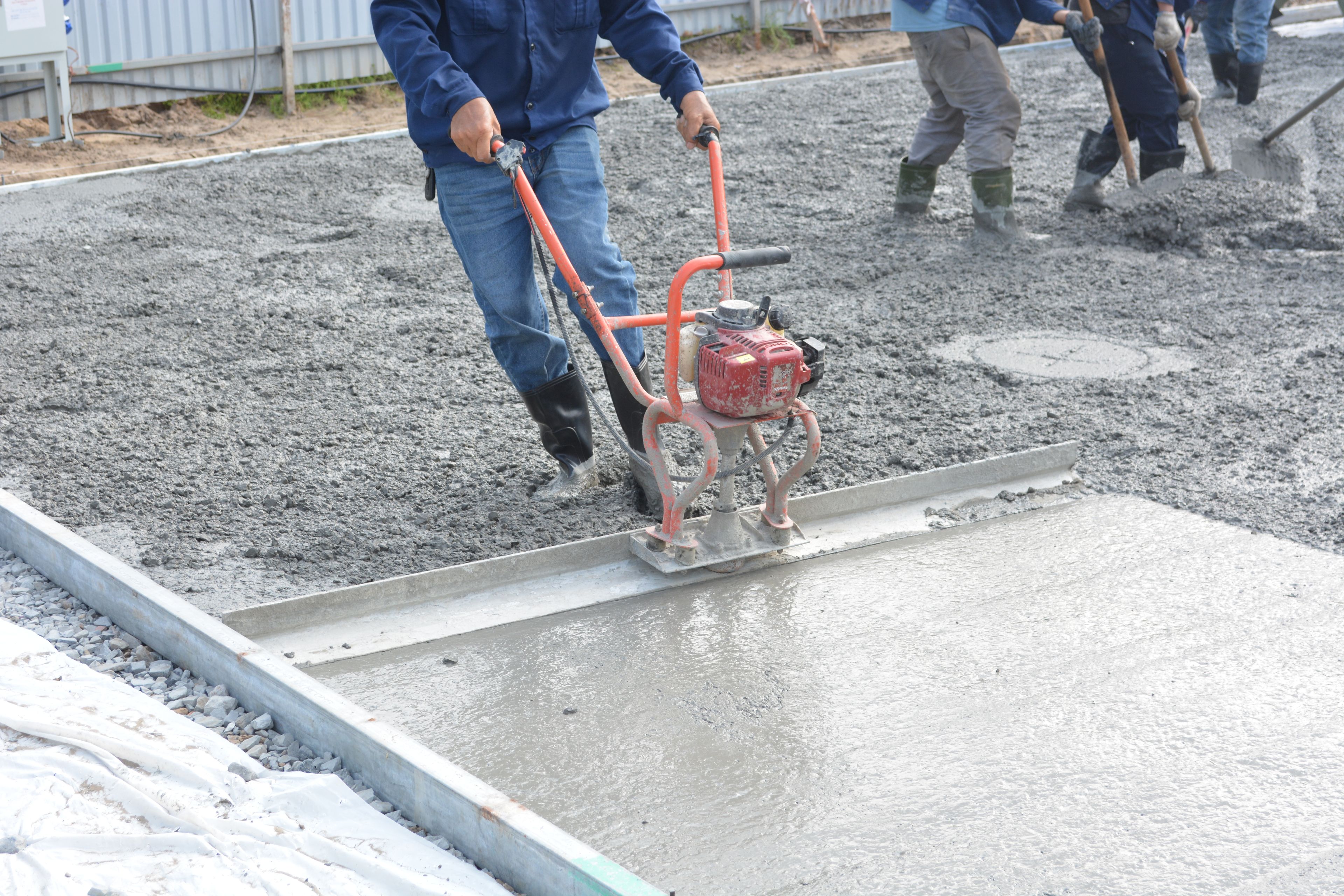 Crew leveling freshly poured concrete